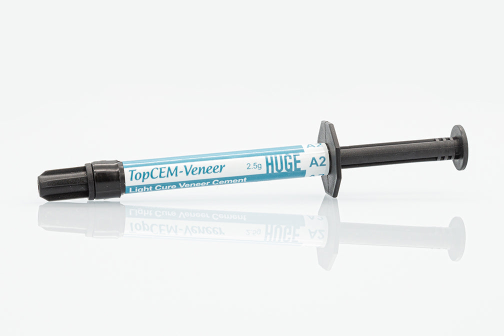 Single syringe of TopCEM-Veneer Light Cure Veneer Cement in blue and white packaging with black dispensing tip, displayed on white background for dental veneer cementation procedures