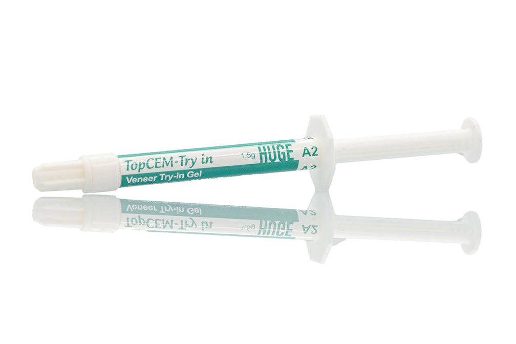 TopCEM Try-in Veneer Try-in Gel syringe with green labeling and clear dispensing tips reflected on mirrored surface, displaying professional dental product packaging for precise color matching