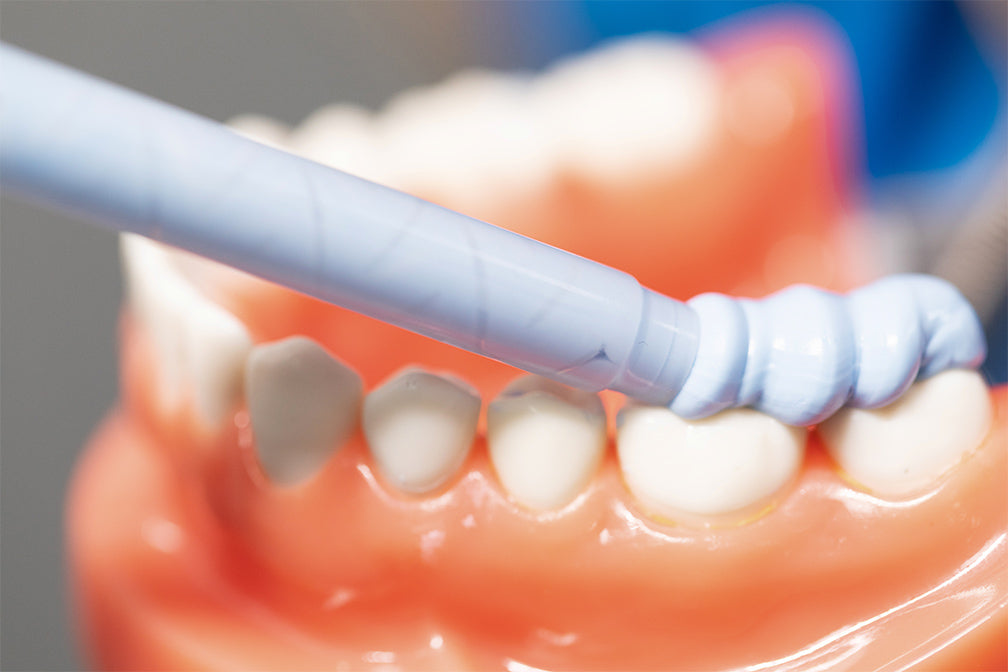 Close-up view of PERFIT Bite Registration material being applied to dental model, showing precise application with spiral mixing tip for accurate occlusal registration and high-quality bite record measurement