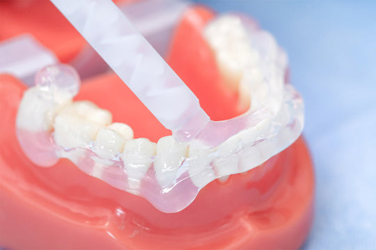 Transparent dental impression material PERFIT Regular Body-Transparent demonstrated on model teeth with mixing applicator, showing clear consistency and precision application for dental procedures