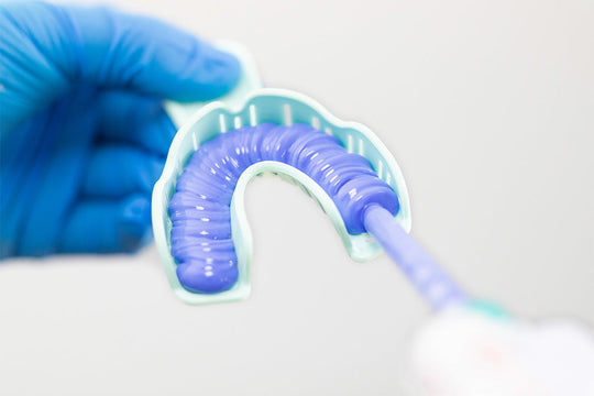 Purple dental impression material in U-shaped tray with precise mixing dispenser for PERFIT Heavy Body-Dispenser Mix, demonstrating professional dental impression taking procedure with accurate material consistency