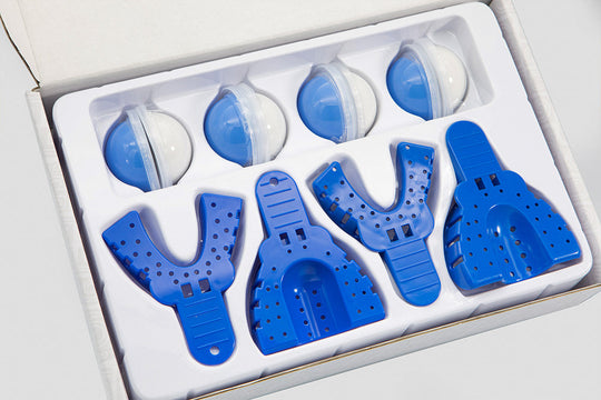 Professional Dental Home Impression Kit featuring white plastic tray packaging containing blue dental impression trays and white putty catalyst containers arranged in organized compartments for precise at-home dental impressions