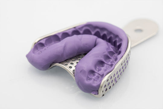 Dental impression tray with purple putty material PERFIT Putty showing detailed mold surface in metal perforated impression tray for precise dental casting and orthodontic procedures