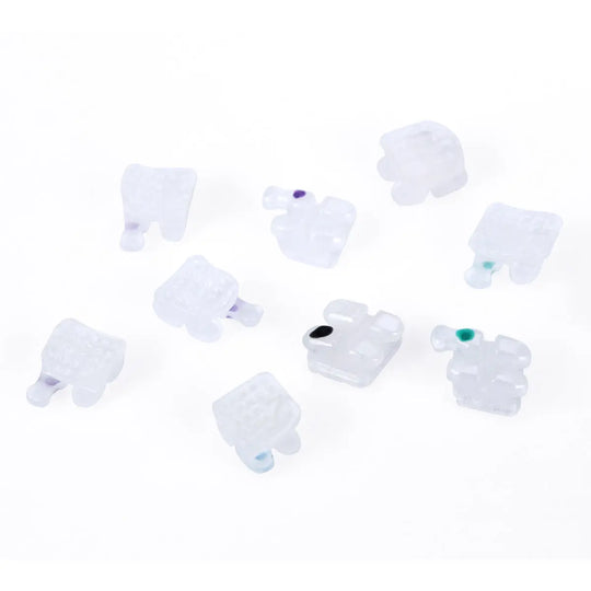 Ceramic Brackets Roth .018 Hooks 345 20pcs/Box: Close-up view of white ceramic orthodontic brackets with colored markers, showcasing their smooth, low-profile design for dental braces and alignment