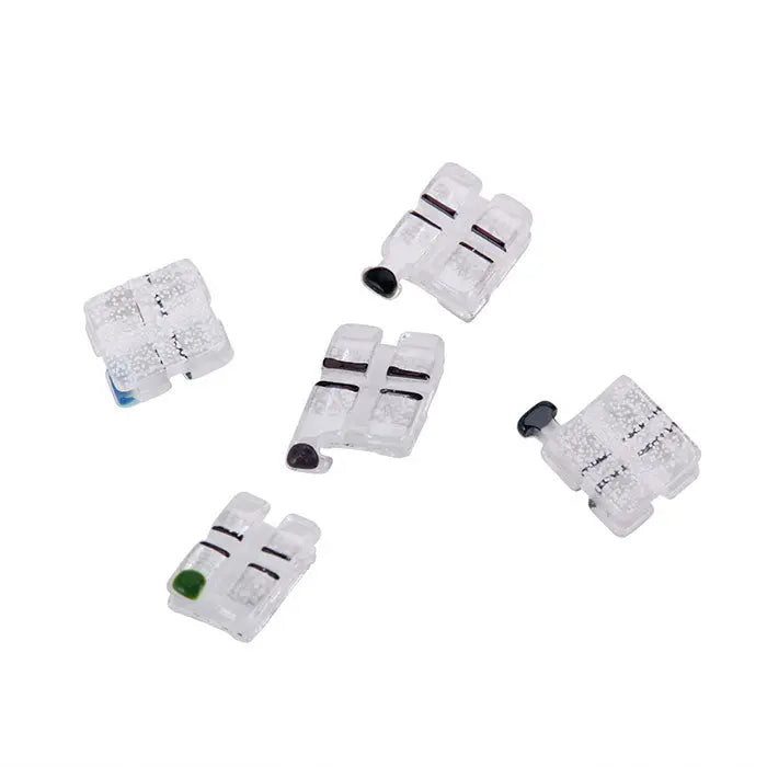 Dental Ceramic Bracket Monocrystalline Sapphire Roth .018 Hooks on 345 20pcs/Box: Set of clear ceramic orthodontic brackets with color-coded markings, showing various sizes and configurations for different tooth positions, arranged on a white background