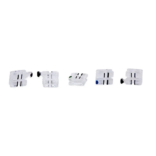 Dental Ceramic Bracket Monocrystalline Sapphire MBT .022 Hooks on 345 20pcs/Box: Five white ceramic dental brackets with black markings and colored dots, arranged in a row against a white background, showcasing their clear and miniature design for orthodontic use.