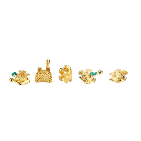 Dental Metal Brackets Mini MBT 0.022 Hooks on 345 Gold Color 20pcs/Box: Five gold-plated dental brackets with green markings, showcasing various designs including textured surfaces and hook attachments, arranged in a row on a white background.