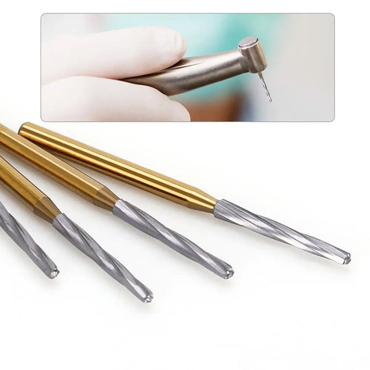 Dental FG Carbide Finishing Burs 28mm Gold 6pcs/Box: Close-up of gloved hand holding dental drill, with four gold-handled carbide burs showcasing their precision tips for dental procedures like sectioning wisdom teeth and preparing tooth shoulders.