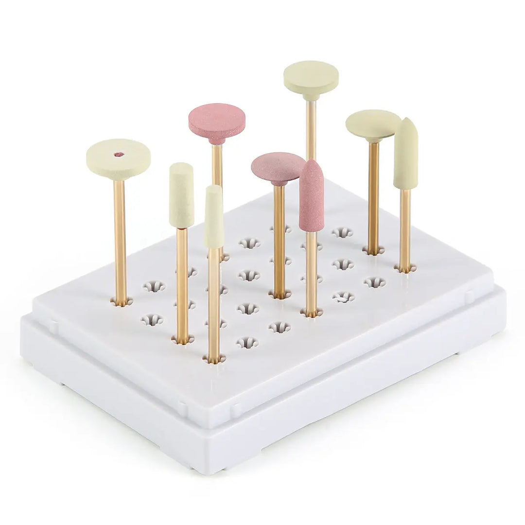 Dental Zirconia Grinding and Polishing Kit with 9 assorted polishers in pink and white, mounted on gold-colored shanks, arranged in a white base block. Professional dental tool set for ceramic and zirconia restoration work.