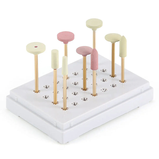 Dental Zirconia Grinding and Polishing Kit with 9 assorted polishers in pink and white, mounted on gold-colored shanks, arranged in a white base block. Professional dental tool set for ceramic and zirconia restoration work.