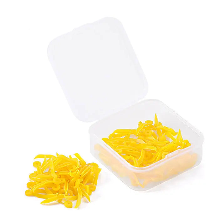 Dental Disposable Wedges With Hole Plastic Tooth Gap Wedge 4 Sizes 100pcs/Box: Yellow plastic dental wedges in transparent storage box, with some wedges scattered outside. Wedges have curved design and circular holes for easy handling.