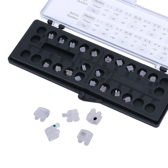 Ceramic Brackets Roth .018 Mesh Base 345/Hooks 20/Box: Dental orthodontic ceramic brackets in a black storage case with clear lid, showing measurement details. Small white ceramic brackets visible outside the case, demonstrating the product's appearance and size.