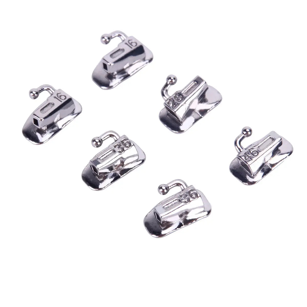 Six silver Buccal Tube 1st Molar Bondable Split Non-Convertible Roth 0.022 orthodontic devices arranged in two rows. Each tube features a small hook and numbered markings, showcasing the precision engineering of these dental appliances used in orthodontic treatments.