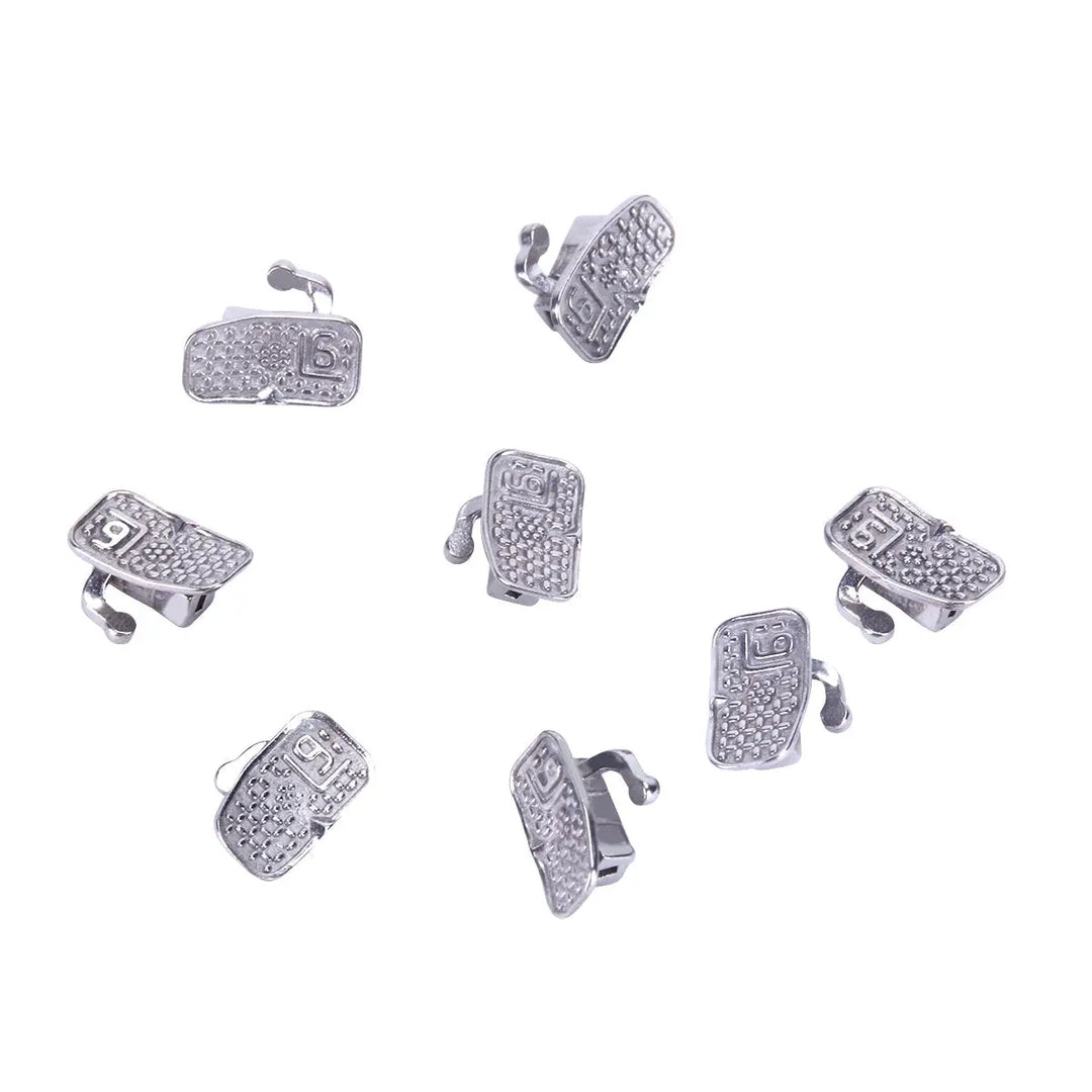 Buccal Tube 1st Molar Bondable Monoblock Non-convertible Roth 0.018 50Sets/Bx displayed as multiple silver-colored orthodontic devices arranged on white background. Each tube features a textured surface and small hook, designed for precise dental alignment.