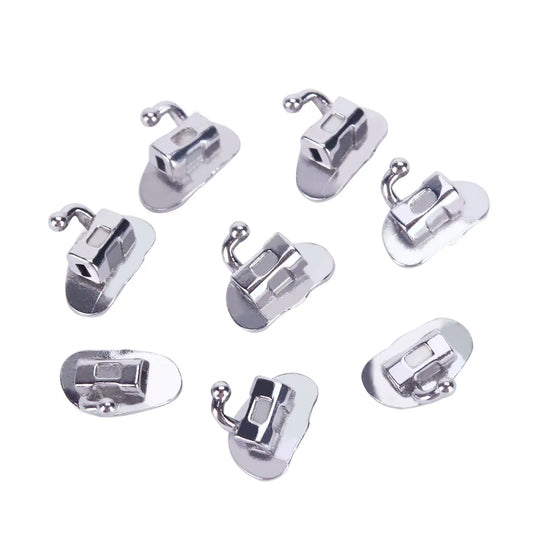 Buccal Tube 2nd Molar Bondable Monoblock Non-convertible Roth 0.022 50Sets/Bx - Set of eight silver-colored orthodontic buccal tubes arranged on white background. Each tube features a rectangular slot and a small hook, designed for precise dental alignment and treatment.