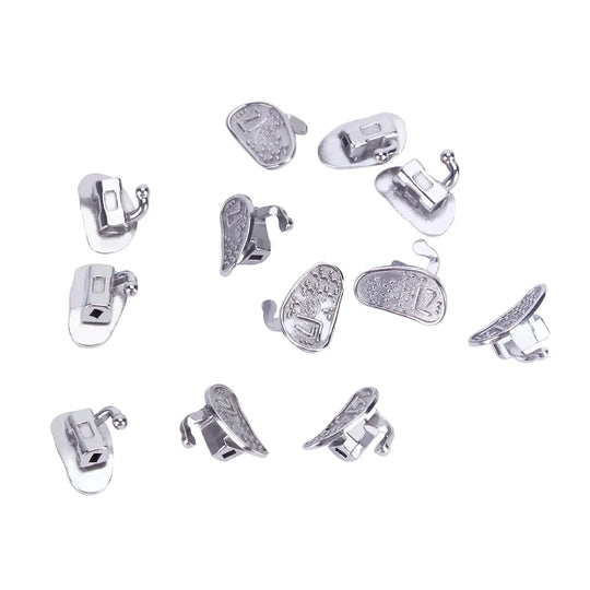 Buccal Tube 2nd Molar Bondable Monoblock Non-convertible Roth 0.022 50Sets/Bx: Multiple silver-colored dental orthodontic buccal tubes scattered on white background, showcasing various angles and designs of the product for second molar applications.