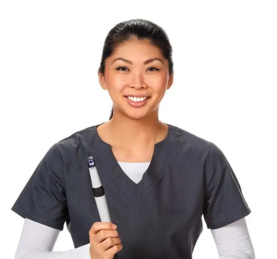 Dental professional smiling while holding CamX Spectra Caries Detection Aid, showcasing its compact design and ease of use in a clinical setting