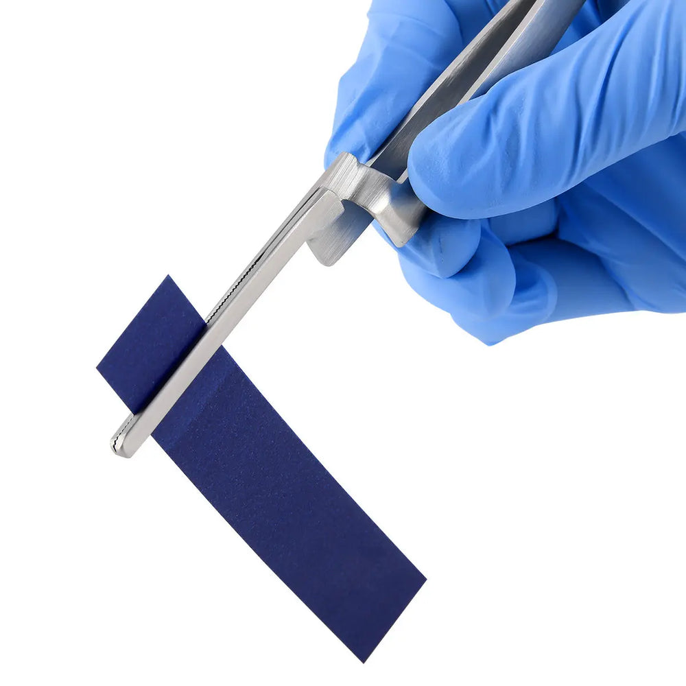 Dental Articulating Paper Holder Serrated Pliers holding blue articulating paper, demonstrating use of Orthodontic Forceps for precise dental work. Hand in blue glove gripping the stainless steel instrument against white background.