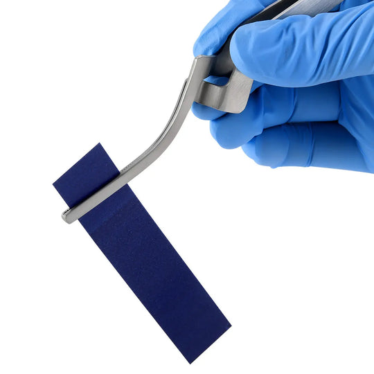 Dental Articulating Paper Holder Serrated Pliers in use, showing gloved hands holding the tool with blue articulating paper. Close-up of the precise dental instrument demonstrating its functionality for occlusion testing in orthodontic procedures.