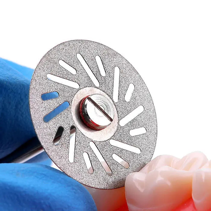 Dental Lab Thin Diamond Disc Cutting Double Side Disk Tool for Polisher Machine: Close-up of circular diamond-coated disc with radial slots held by blue-gloved hand, showcasing its thin, precise design for dental work on ceramic and metal materials.