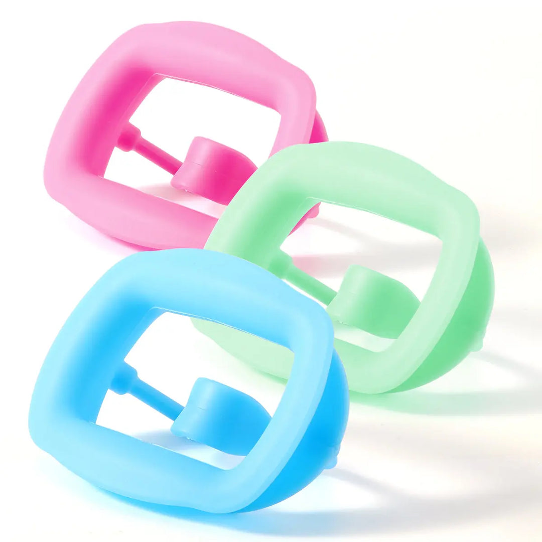 Dental Soft Mouth Opener Orthodontic 3D Intraoral Lip Cheek Retractor in pastel pink, green, and blue colors. Three soft silicone mouth openers arranged together, showcasing their simple structure and comfortable design for dental examinations.