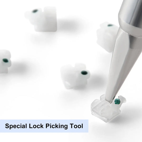 Dental Self-ligating Ceramic Brackets Clear Roth/MBT 0.022 with hook 3,4,5 shown with special lock picking tool. Close-up of white ceramic brackets with green centers and metal tool for opening self-ligating brackets, demonstrating precise dental orthodontic equipment.