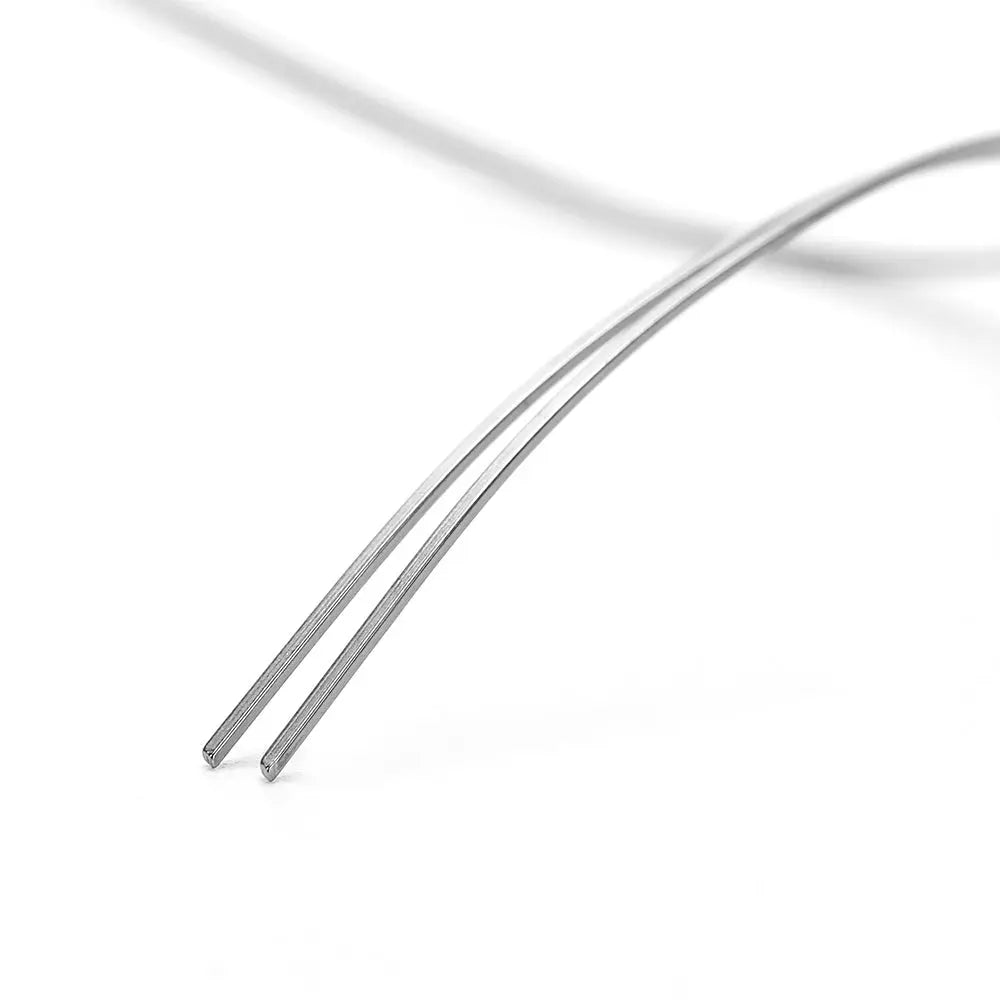 Close-up of Archwire NiTi Reverse Curve True Form Rectangular 0.016 x 0.025 Upper 2pcs/Pack, showing two thin, silver-colored metal wires with a slight curve, highlighting the product's precision and quality for orthodontic use.