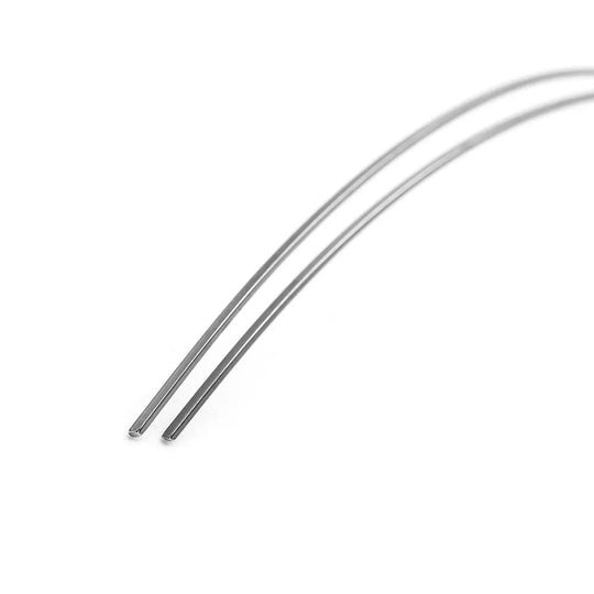 Archwire Niti Reverse Curve Rectangular 0.016 x 0.016 Upper 2pcs/Pack: Close-up of two thin, curved metal wires made of NITI alloy for orthodontic treatment, showing their smooth surface and precise rectangular shape on a white background.