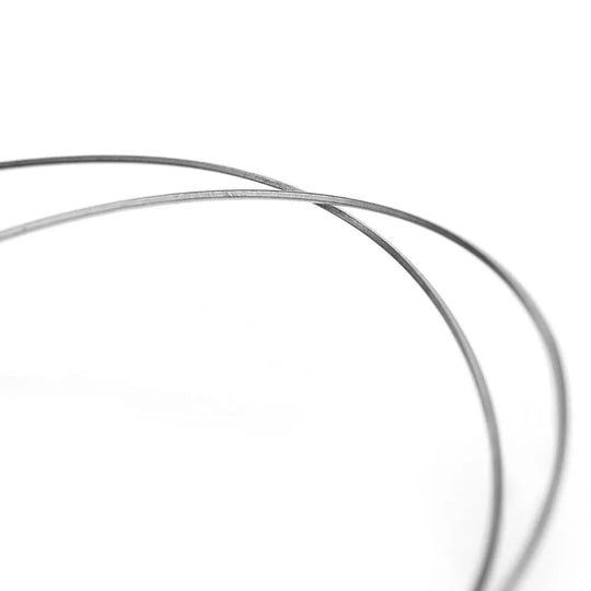 Archwire Niti Reverse Curve Rectangular 0.016 x 0.016 Upper 2pcs/Pack - Close-up view of two thin, curved metal wires against a white background, showcasing the flexible and precise nature of dental archwires used in orthodontic treatments.