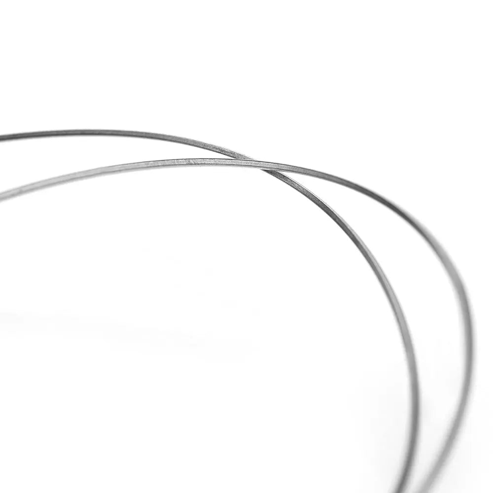 Archwire Niti Reverse Curve Rectangular 0.016 x 0.025 Upper 2pcs/Pack - Close-up view of two thin, curved metal wires against a white background, showcasing the flexibility and precision of orthodontic archwires used in dental treatments.