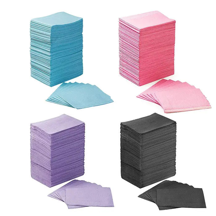 Dental Disposable Patient Bibs 13"x18" 2-Ply Paper/1-Ply Poly 125pcs/Pack shown in stacks of blue, pink, purple, and black colors. Each stack displays multiple layers of thin, absorbent bibs with a few individual sheets visible in front, showcasing the product's variety and quantity.