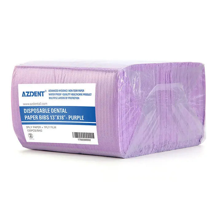 Dental Disposable Patient Bibs 13"x18" 2-Ply Paper/1-Ply Poly 125pcs/Pack in purple packaging. Large rectangular block of stacked bibs with product label visible, showing brand name AZDENT and product details. Hygienic dental supplies for patient protection.