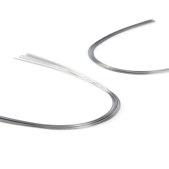 Archwire NiTi Super Elastic Ovoid Form Round 0.014 Upper 10pcs/Pack: Curved dental archwires in silver and white colors, showcasing the flexibility and shape of NiTi super elastic orthodontic wires used for teeth alignment in dental treatments.