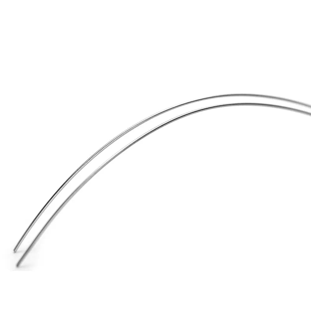 Arch Wire NiTi Reverse Curve True Form Round 0.018 Upper 2pcs/Pack - Close-up of curved, shiny metal orthodontic wires against white background, showcasing the smooth, rounded shape and flexible nature of the NiTi archwires used in dental treatments.