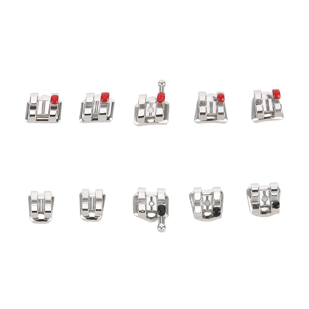 Dental Metal Brackets Mini MBT Slot .022 Hooks on 3 20pcs/Pack - Close-up of ten orthodontic brackets arranged in two rows, showing silver metal construction with red markers and hooks visible on some brackets, demonstrating various angles and designs for dental use