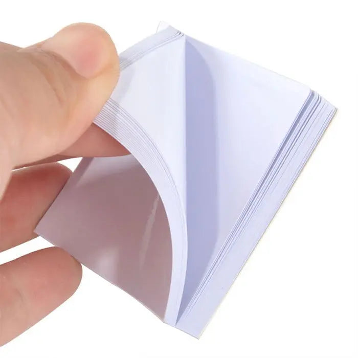 10 Pads Dental Mixing Pad 2x2 inch Bounded on 2 Sides 50Sheets/Pad - Close-up of hand holding disposable dental mixing pad, showing white paper sheets bound on two sides, demonstrating easy tear-off feature for dental material mixing and clean-up